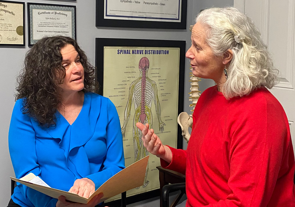 Dr. Kim Pollack explaining the spine and nervous system to a patient in her Groton, CT office